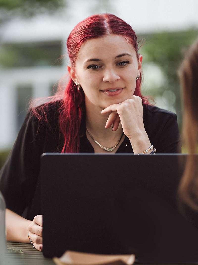Anni arbeitet am laptop und lächelt vor sich hin